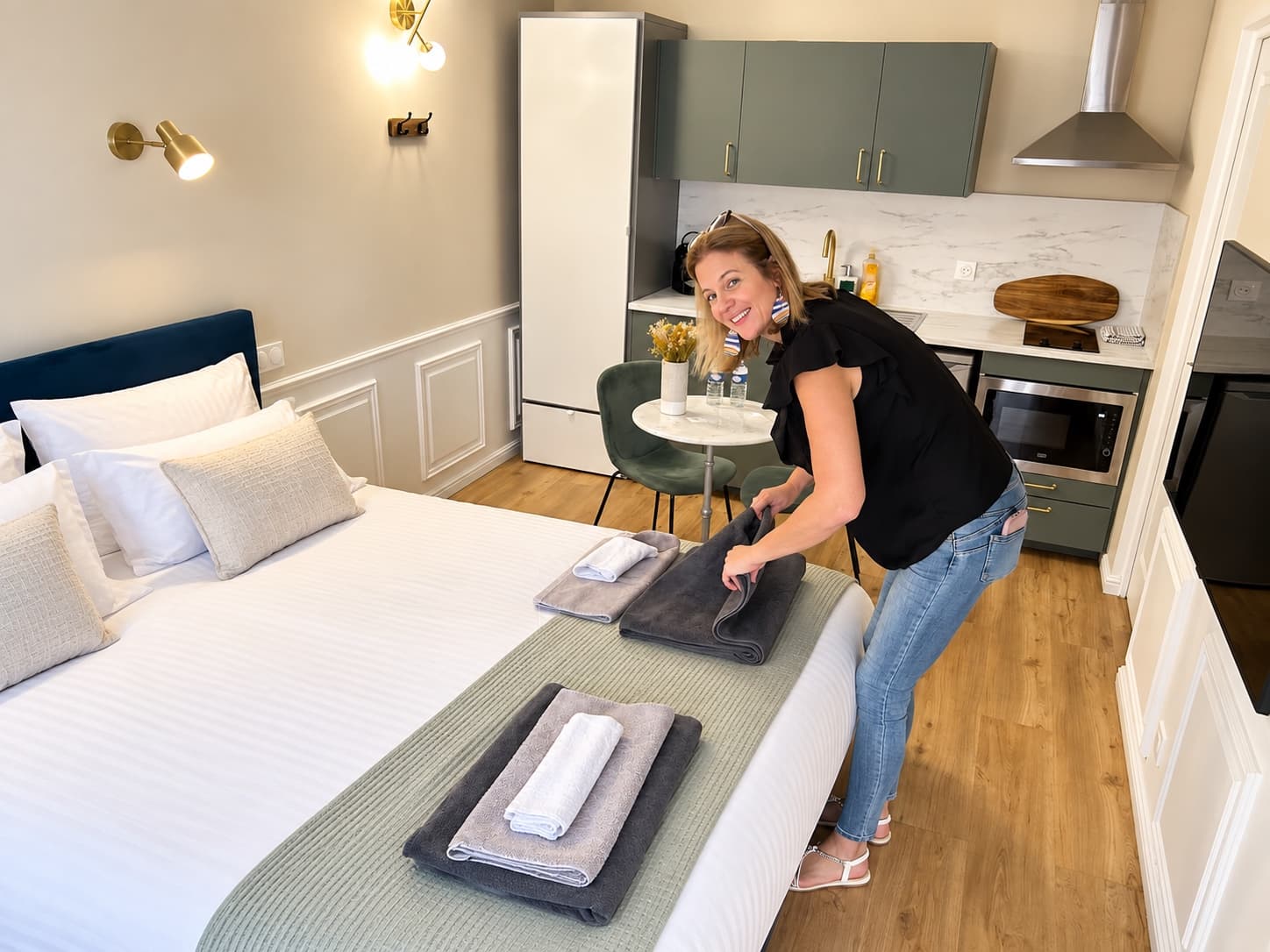Alexandra Guyon dispose les serviettes pliées sur le lit d’un appartement loué en courte durée
