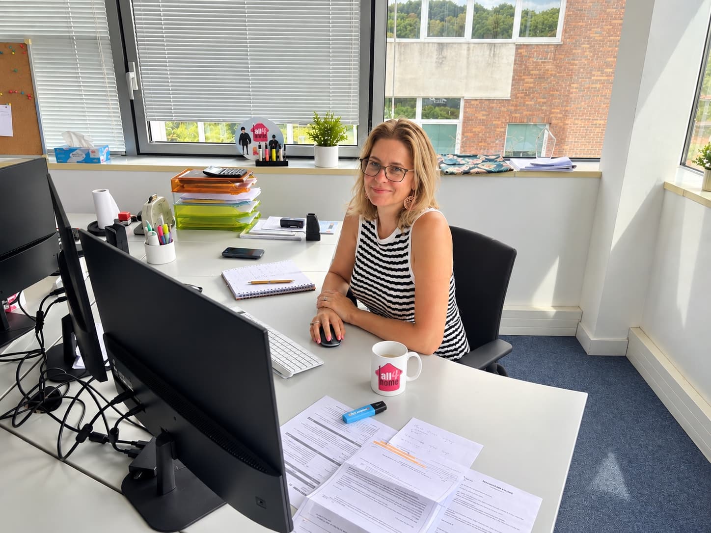Alexandra Guyon à son bureau de Bièvres, devant un écran, un carnet et des dossiers