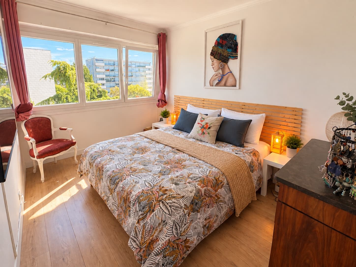Chambre à coucher d’un client, lit fait avec un couvre-lit à motifs et parquet dégagé