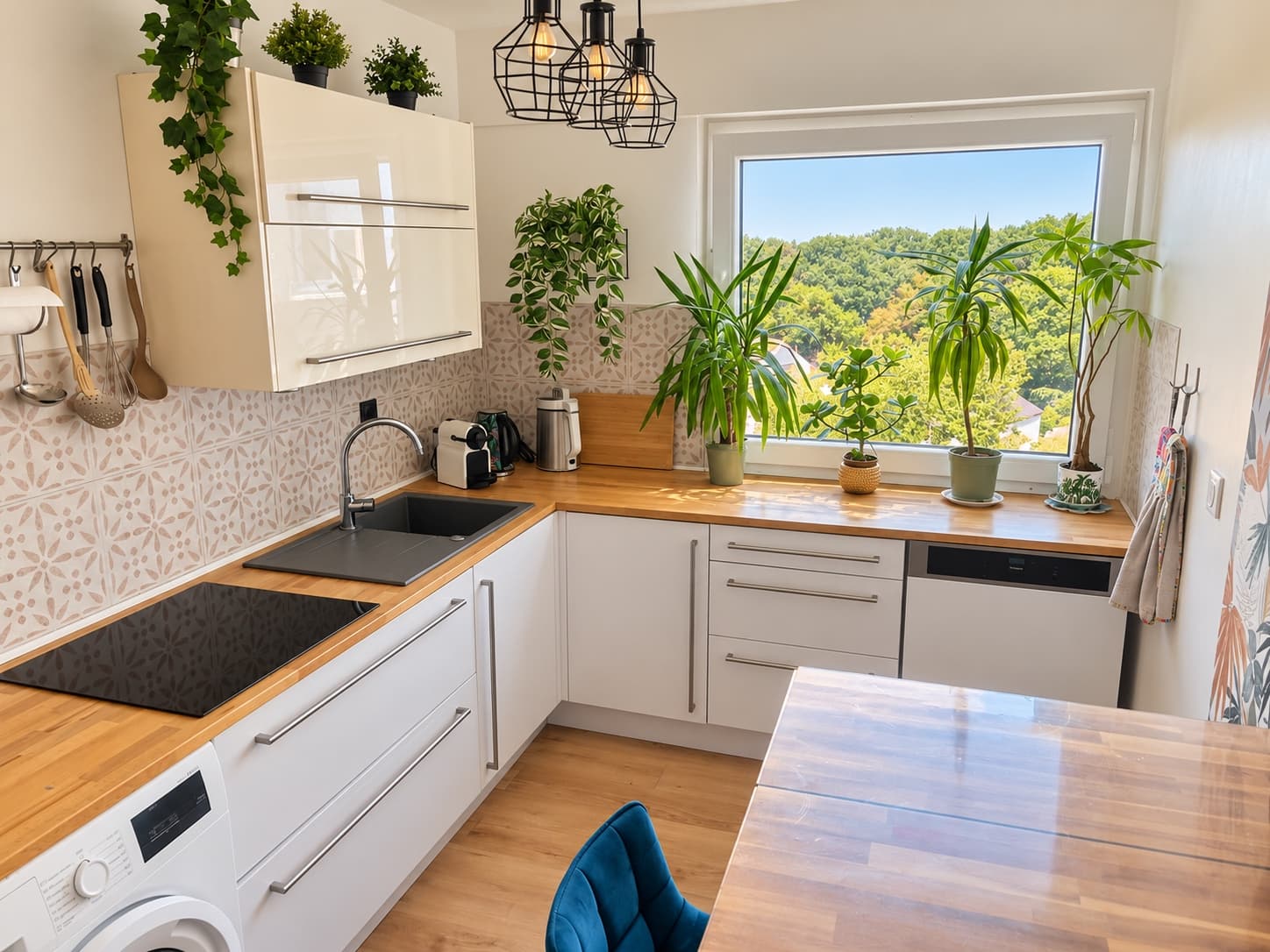 Cuisine d’un client, plan de travail en bois dégagé et plantes devant la fenêtre